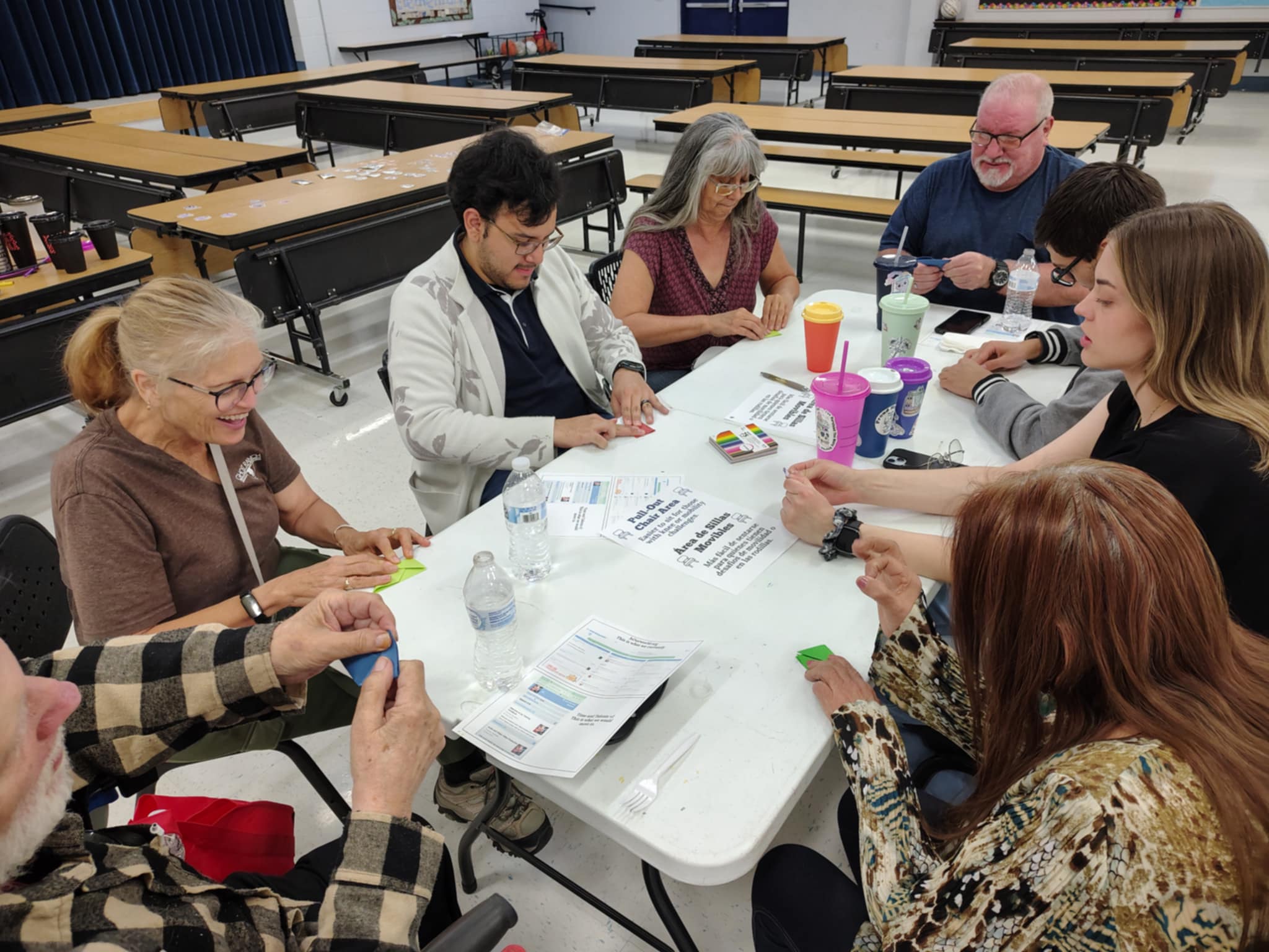 people at a gathering folding paper